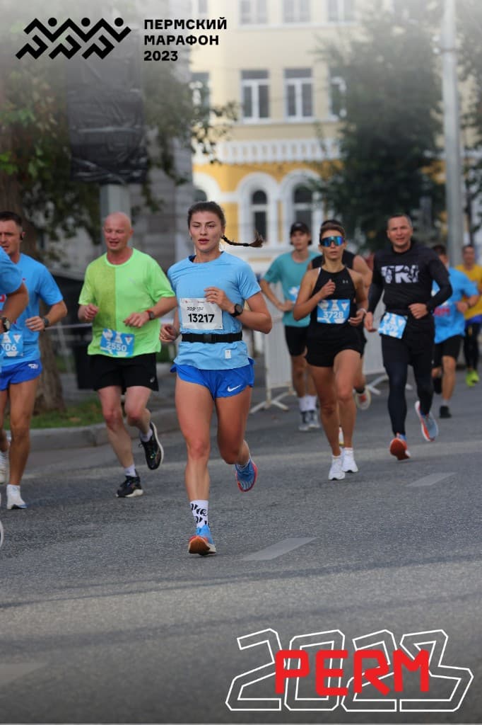 Пермский марафон — дистанционная толпа бегунов в раннем утреннем свете.